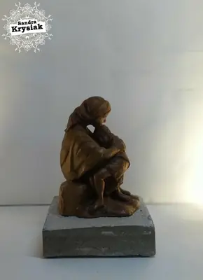 Figura adulta con un niño tallada en madera