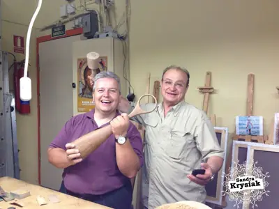 Dos personas sonrientes con una talla en el taller