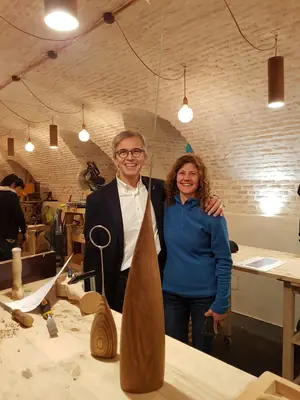 Dos personas junto a una escultura en una sala abovedada