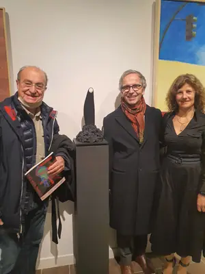 Tres personas con un premio en una exposición