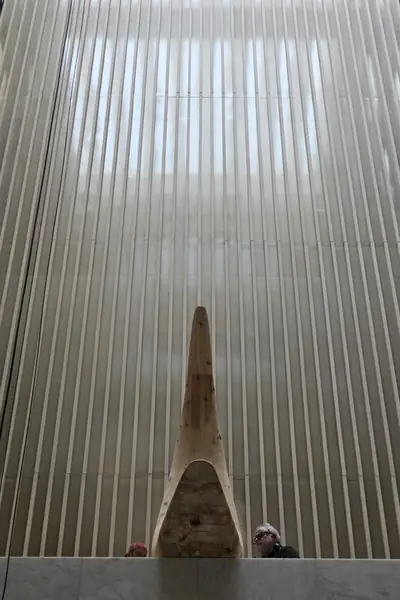 Gran escultura de madera con forma de arco, expuesta en el vestíbulo de un edificio