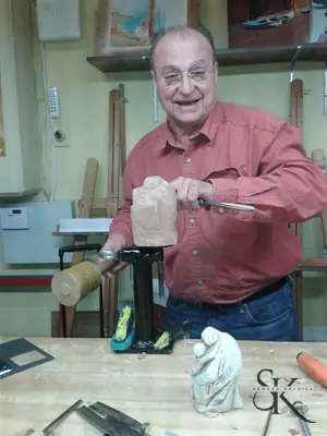 Alumno sonriente con una herramienta en la mano