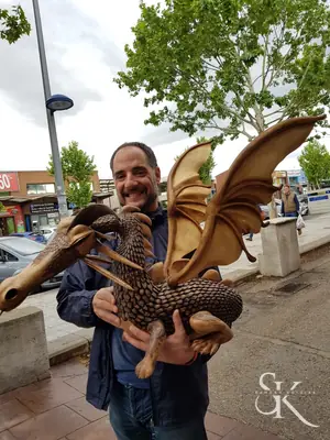 Alumno que sostiene una gran talla de dragón