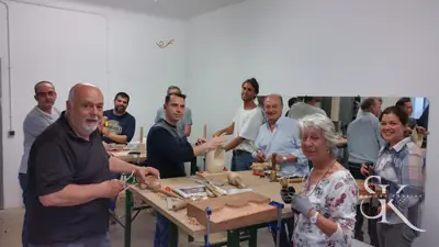 Alumnos alrededor de una pieza sujeta al banco
