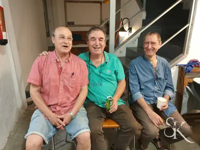 Tres alumnos sentados junto a la escalera