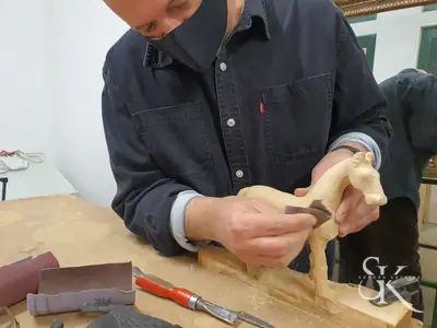 Alumno tallando una forma curva de madera