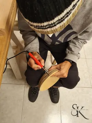 Manos trabajando un cuenco con una herramienta