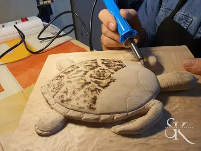 Manos decorando una tortuga de madera
