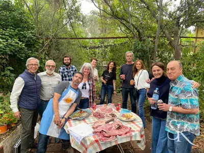 Grupo sonriente junto a una comida al aire libre