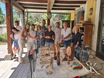 Grupo junto a una mesa con piezas al aire libre