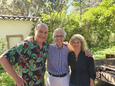 Tres personas sonrientes en un jardín