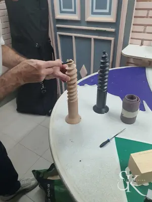 Manos trabajando una pieza torneada de madera