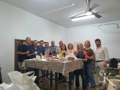 Grupo junto a una mesa con comida en el aula