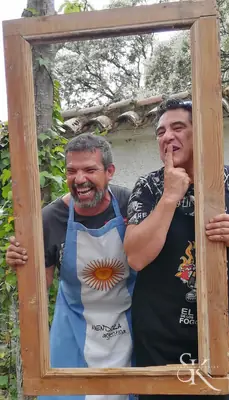Dos personas posan dentro de un marco de madera