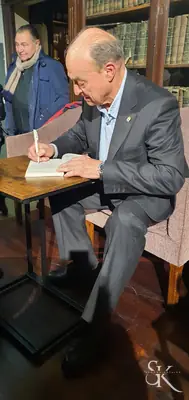 Alumno escribiendo en un libro sentado a una mesa
