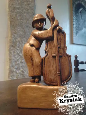 Figura junto a un contrabajo tallado