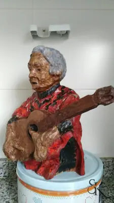 Figura policromada tocando la guitarra