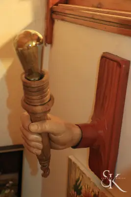 Mano tallada que sostiene una antorcha