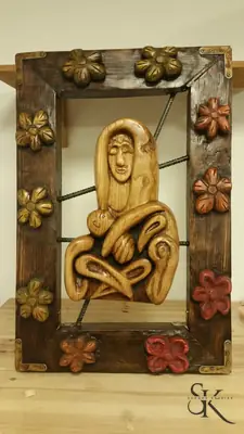 Figura sentada en un panel con marco floral