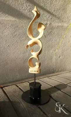Escultura clara de formas curvas sobre base negra