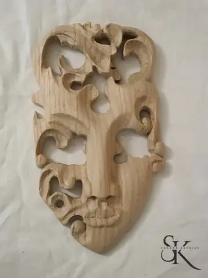 Máscara de madera clara con huecos decorativos