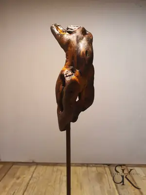 Figura femenina sobre un soporte metálico