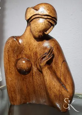 Figura femenina tallada con los brazos recogidos