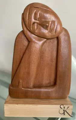 Figura sentada con las manos en la cara