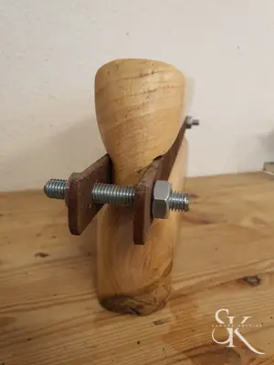 Pieza de madera atravesada por un tornillo metálico