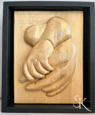 Dos manos superpuestas en un relieve enmarcado