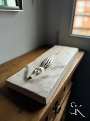 Pieza de madera con relieve, apoyada sobre un banco de trabajo