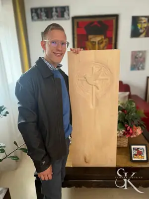 Alumno junto a un panel de madera en proceso