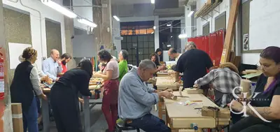 Alumnos trabajando alrededor de las mesas del taller