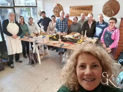 Alumnos posan junto a una mesa con herramientas y tallas en proceso