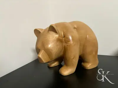 Rinoceronte tallado en madera clara sobre fondo oscuro