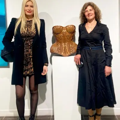 Sandra Krysiak y la diseñadora Maya Hansen junto al corsé tallado en madera, en el 57 Premio Reina Sofía